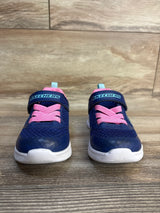 Navy blue Skechers toddler sneakers with pink laces and white soles on wood floor