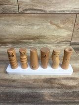 Front view of Lovevery Wooden Emotion Dolls: six wooden peg figures with different facial expressions on a white base