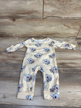 Flat lay of yellow newborn koala print coverall showing snap leg closures and fold-over cuffs on wood background
