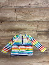 Flat lay of baby long-sleeve rash guard, rainbow stripes, front quarter-zip, size 12-18 months on wood floor
