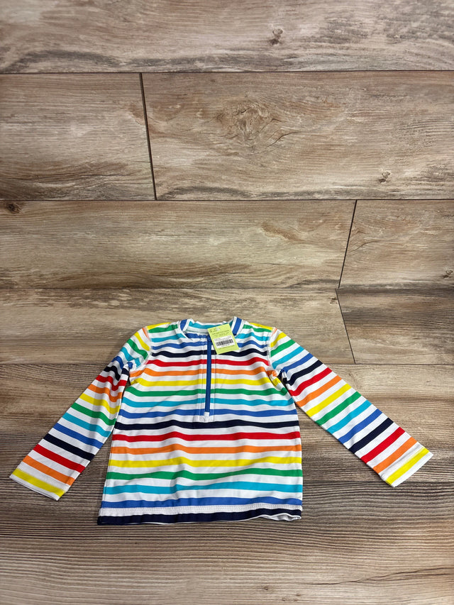 Flat lay of baby long-sleeve rash guard, rainbow stripes, front quarter-zip, size 12-18 months on wood floor