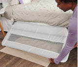 Angled view of Regalo Guardian swing-down bedrail in white showing lowered mesh panel and metal mounting bar on a bed