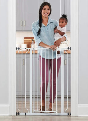 Front view of Regalo Extra Tall walk-through metal baby gate showing vertical bars and latch in a white doorway