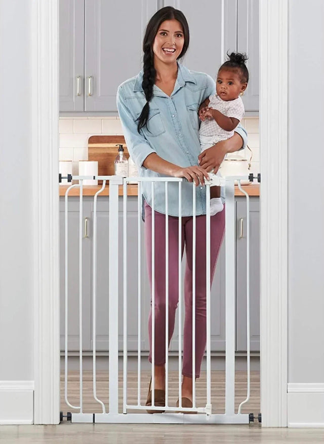 Front view of Regalo Extra Tall walk-through metal baby gate showing vertical bars and latch in a white doorway