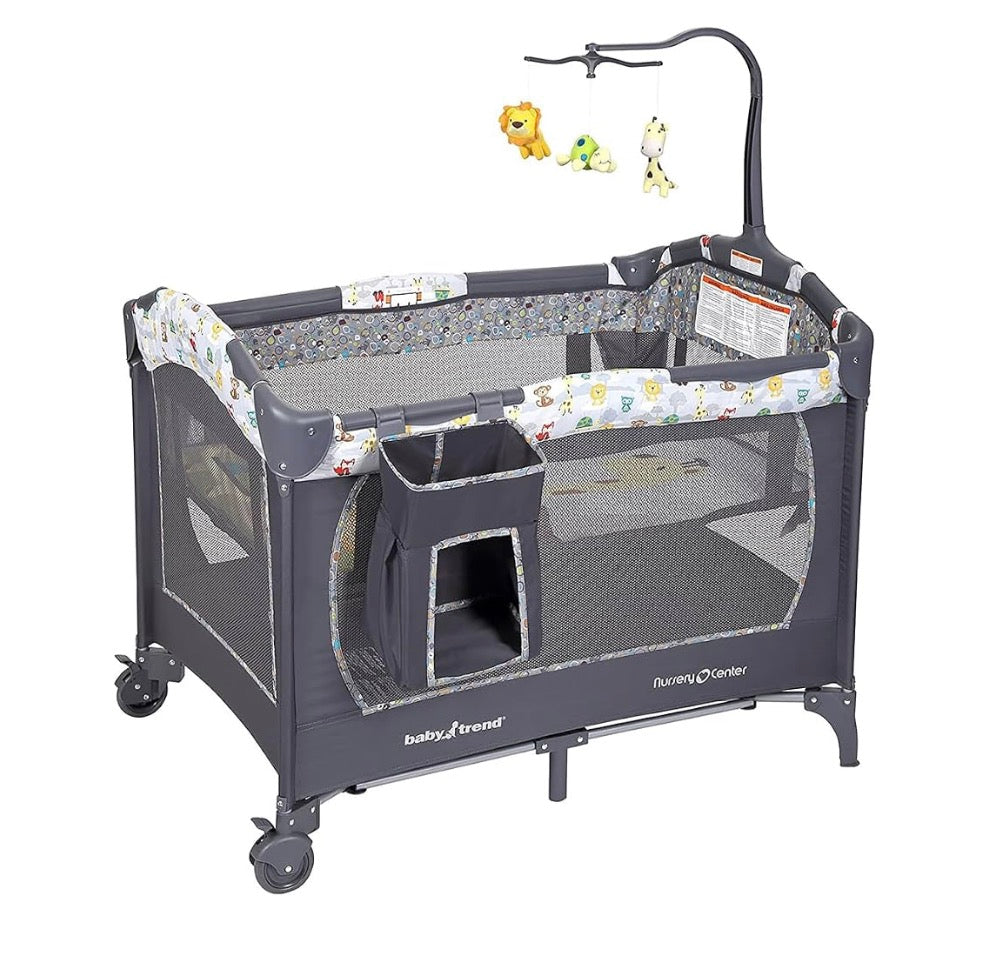 Three-quarter view of Baby Trend Nursery Center showcasing mesh sides and hanging toy mobile with white background