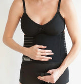 Woman wearing black postpartum support belly wrap and nursing bra for maternity recovery
