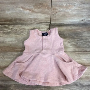 Flat lay of blush ribbed twirl baby dress, size 0-3m, showing sleeveless bodice, front snaps and pocketed skirt on wood background