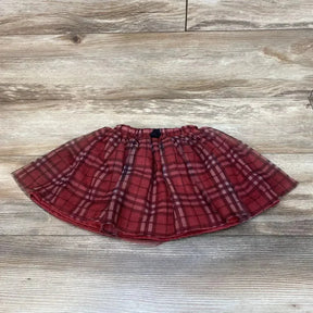Flat lay of red plaid toddler skirt size 2T showing elastic waistband and layered tulle overlay on light wood floor
