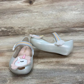 Three-quarter view of Mini Melissa Glitz Unicorn Mary Jane (size 6C) showing unicorn toe appliqué and pastel rainbow strap on wooden surface