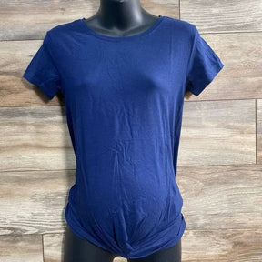 Front view of navy Gap maternity twist-knot tee showing knotted hem and short sleeves on black torso with wood background