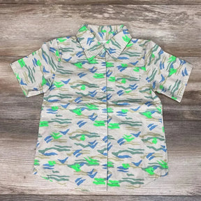 Flat lay of beige 4T Miki Miette button-front short-sleeve shirt showing blue and neon green abstract print on wood floor
