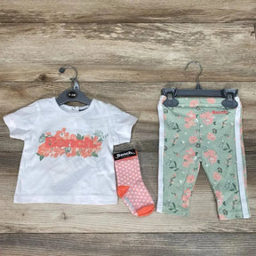 Flat lay of Bench baby set: white tee with coral floral logo, mint floral leggings with side stripes, pink dot sock on wood, size 0-3M visible