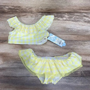 Top-down view of yellow gingham 2-piece toddler bikini size 2T showcasing ruffle trim and attached tag on light wood background