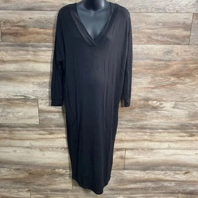 Front view of black Quince maxi dress on mannequin showing V-neck, long sleeves, relaxed ankle-length fit on wood background