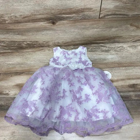 Flat lay of white 2T toddler dress with lavender floral embroidery and tulle skirt on wood floor