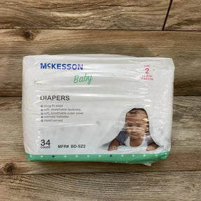 Front view of McKesson diaper pack (Size 2, 12–18 lb, 34 count) showcasing package front with baby photo and feature list on wood background