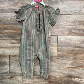 Front view of green Penelope Mack Henley jumpsuit 12M with ruffle sleeves, henley placket, elastic ankles on wood floor