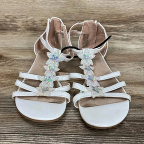 Front view of white toddler sandals (size 3Y) showcasing iridescent flower T-strap embellishments and ankle straps on wood floor