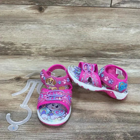 Front view of pink Paw Patrol toddler ankle-strap sandals size 7C showing character graphics, Velcro straps and white-pink molded sole on a wooden surface