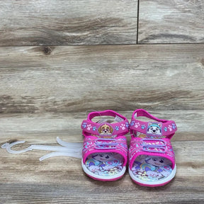 Front view of pink Paw Patrol Adventure ankle-strap toddler sandals, adjustable Velcro straps and character-printed insoles on wood background