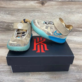 Front view of toddler Nike Kyrie 7 Ripple sneakers showcasing tan mesh upper, teal ripple sole, and velcro strap with shell logo on a black Kyrie shoebox