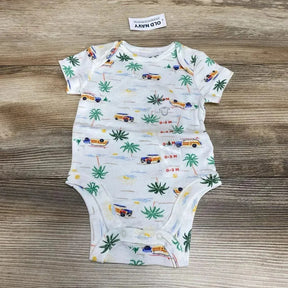 Flat-lay of white infant bodysuit 0-3M with navy beach-print vans and palm trees, snaps at crotch, on wood background