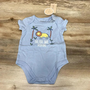 Flat lay of blue baby bodysuit showcasing yellow lion graphic and 'HEAR ME ROAR' text on wood background