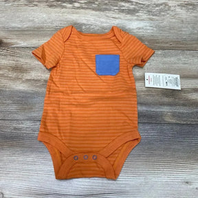 Flat lay of orange striped Cat and Jack bodysuit (0-3 months) showcasing a blue chest pocket and three snap closures on a wood background