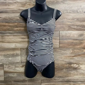 Front view of black and white striped tankini set showcasing ruched maternity tummy panel and fitted top on black torso mannequin against wood background