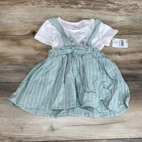 Flat lay of Minnie two piece seafoam striped suspender skirt with elastic ruffle waist and white tee on wood background