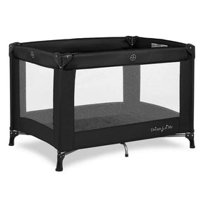 Three-quarter view of Dream On Me Nest playard in black showing mesh sides and metal legs on white background