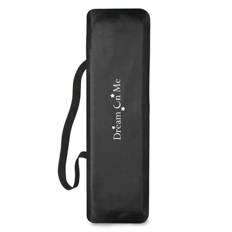 Folded Dream On Me Nest playard in black carrying bag with shoulder strap and Dream On Me logo on white background
