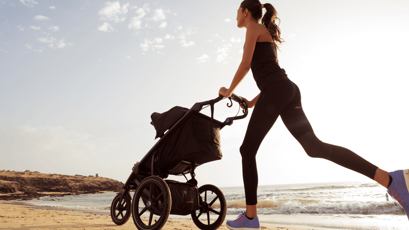 Mother pushing a jogging stroller 