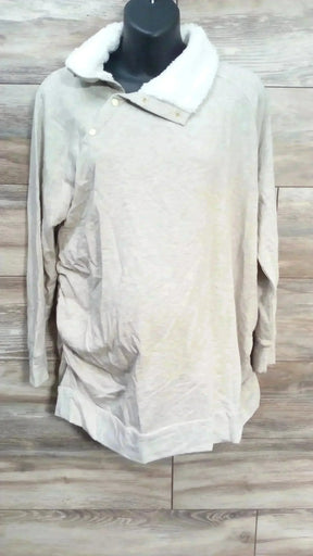 Front view of oatmeal maternity sweatshirt with sherpa snap collar and ruched sides on black mannequin, wood background