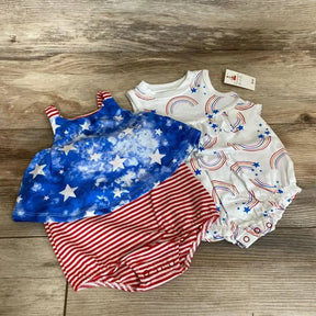 Top-down of two Cat and Jack baby rompers: white rainbow-print and blue star with red-striped bottoms on wood