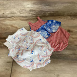 Flat lay of two baby rompers: white rainbow-and-blue-star romper and red-and-white striped romper with blue stars