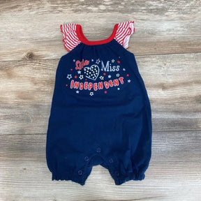 Flat-lay of navy baby romper showing 'Little Miss Independent' graphic, striped ruffle sleeves, and snap crotch on wood background