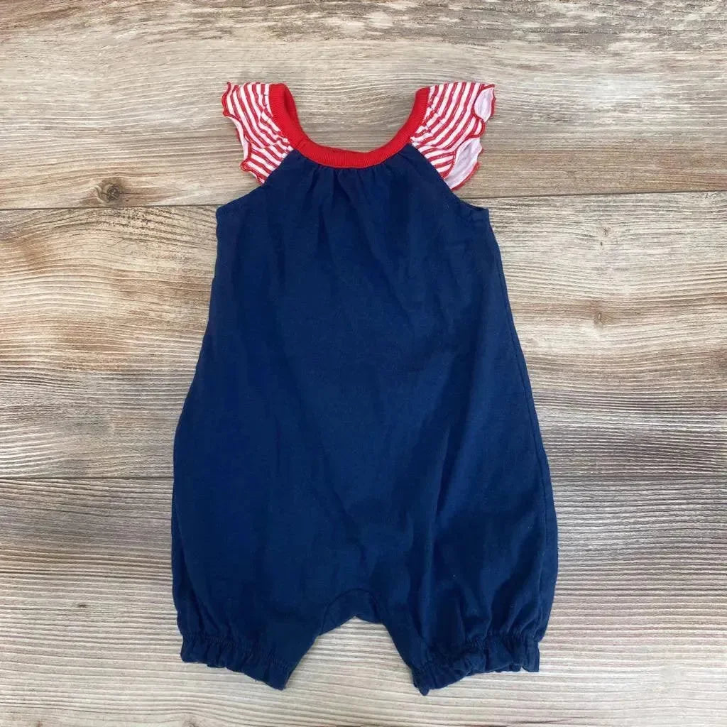 Flat lay of navy baby romper (0-3 months) showcasing red-and-white striped ruffle sleeves and elasticized leg openings on wood background