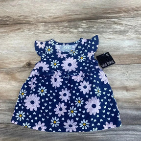 Front view of Okie Dokie navy baby dress and bloomers showcasing pink daisy print and flutter sleeves, size 3M on wood floor