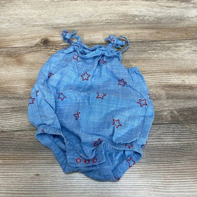 Flat lay of blue Cat & Jack chambray baby romper (0-3 months) showing red star embroidery, ruffle straps and snap crotch on wood background