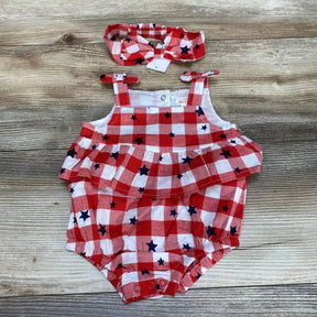 Flat lay of red and white gingham baby romper with navy stars and matching headband, ruffled bodice, tied shoulder straps, snap crotch on wood background
