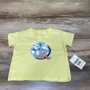 Flat lay of yellow 12m baby t-shirt showing round blue-white abstract print with pink squiggle on wood backdrop