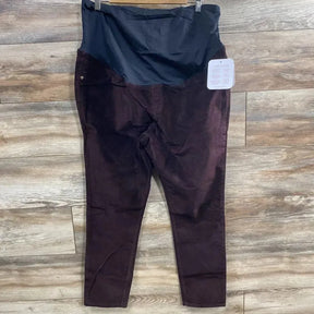 Flat lay of Isabel maternity crossover-panel skinny jeans with black crossover tummy panel on wood floor