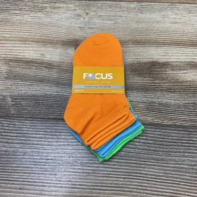 Top view of 3-pack baby ankle socks (orange, blue, green) showing Focus label with size 0-12 on wood tabletop