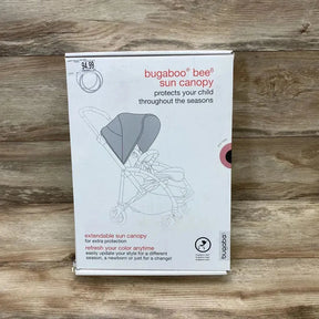 Front view of boxed Bugaboo Bee6 sun canopy showing illustration of extendable pink canopy on wooden surface background