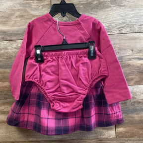 Front view of toddler two-piece long-sleeve dress and matching bloomer, pink top with pink-purple plaid skirt on hanger over wood floor