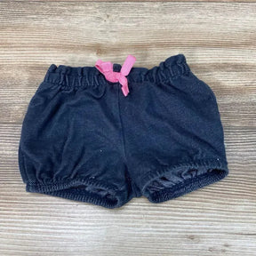 Top view of Jumping Beans navy baby shorts, 3 months, showing elastic waistband and pink drawstring bow on wood background