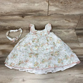 Flat lay of Cupcakes and Cashmere 3T floral dress and headband with ruffle straps and layered skirt on wood floor