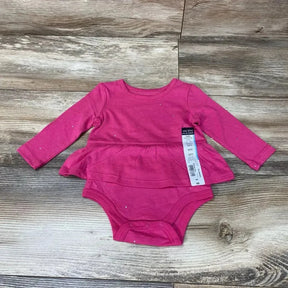 Flat lay of pink long-sleeve skirted bodysuit size 6M showcasing peplum skirt and snap crotch closures on wood floor background
