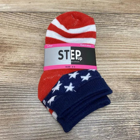 Top-down view of toddler socks showing red and white stripes and navy stars with STEP up label SIZE 2-3 on wood